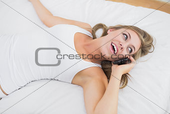 Calm woman phoning lying on the bed