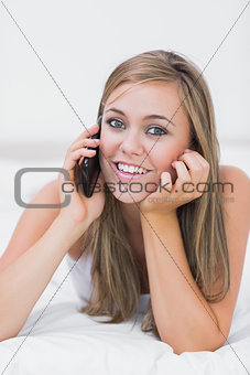 Beautiful woman phoning lying on the bed