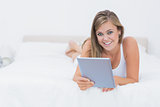 Smiling blonde woman with her tablet pc
