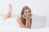 Woman lying on the bed with her laptop