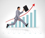 Businessman holding his suitcase running against a graph