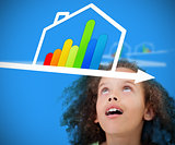 Girl standing against a blue background looking at energy efficient house graphic