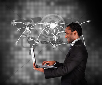 Man in suit working with laptop against a background