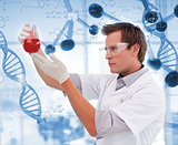 Scientist looking at beaker of red liquid