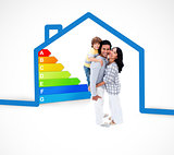 Smiling family standing with a blue house illustration with energy rating