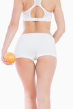 Woman in sportswear holding orange