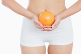 Fit woman holding fresh orange