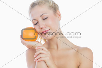 Topless woman holding orange