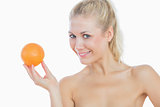 Happy topless woman holding fresh orange