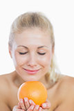 Happy woman smelling fresh orange