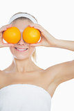 Woman holding oranges in front of eyes