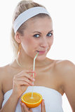Woman drinking from a straw in an orange