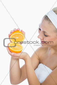 Happy woman holding slices of orange