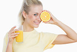 Happy woman with glass of juice and slice of orange