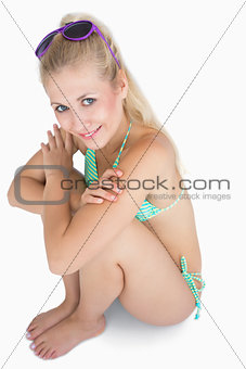 Happy woman in bikini sitting with arms crossed