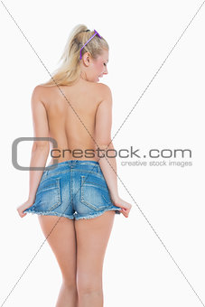 Topless young woman in hot pants