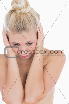 Naked woman covering ears