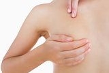 Closeup of naked woman examining breast