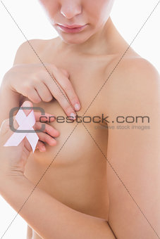 Naked woman holding breast cancer ribbon