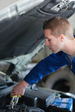 Car mechanic adjusting engine