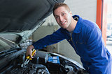 Male mechanic fixing car engine