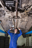Portrait of mechanic working under car