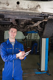 Repairman preparing checklist under car