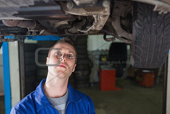 Repairman standing under car