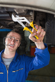 Mechanic repairing car with pliers