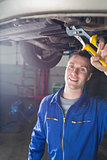 Happy male mechanic repairing car
