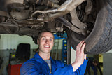 Male mechanic examining car tire