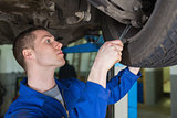 Auto mechanic repairing car with spanner