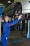 Male mechanic examining car tire