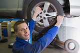 Male mechanic changing car tire