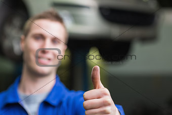 Auto mechanic gesturing thumbs up