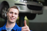 Car mechanic gesturing thumbs up