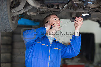 Mechanic on call while examining car