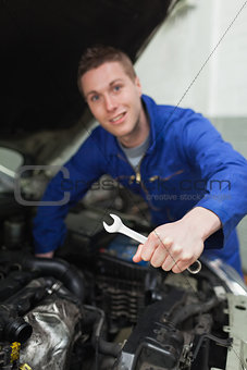 Mechanic with spanner repairing car