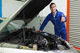 Mechanic by car gesturing thumbs up