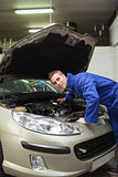 Auto mechanic examining car engine