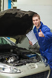 Mechanic by car showing thumbs up