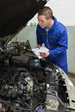 Car mechanic preparing checklist