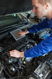 Mechanic with tablet pc repairing car