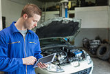 Auto mechanic working on tablet pc