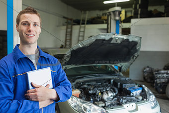 Happy car mechanic with tablet pc