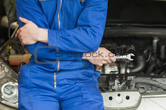 Mechanic leaning on car