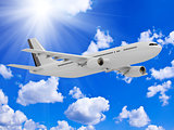 White passenger airliner flies under the bright sun