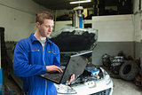 Mechanic using laptop in garage