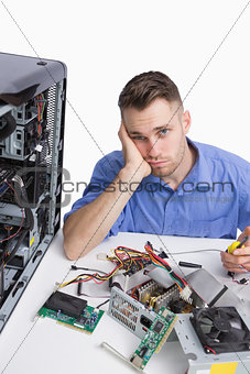 Portrait of young tired computer engineer with cpu parts