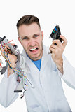 Portrait of young it professional yelling with cpu parts in hands